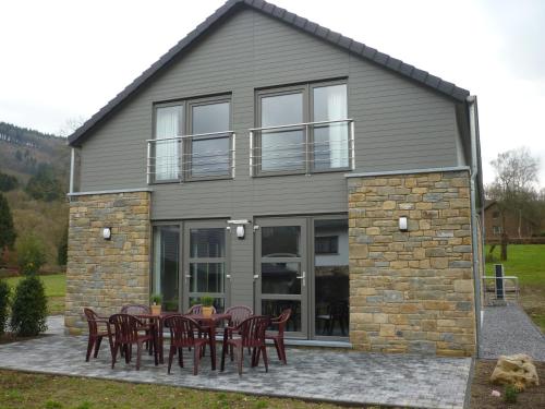a house with tables and chairs in front of it at Les midis au vert - Les Loges - 11 personnes in Stavelot
