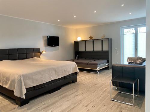 ein Schlafzimmer mit einem Bett, einem Sofa und einem TV in der Unterkunft "Mittendrin" in Garmisch in Garmisch-Partenkirchen