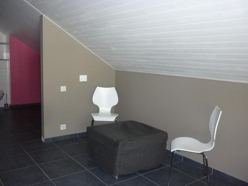 a room with two chairs and a ottoman at Les midis au vert - Les Loges - 11 personnes in Stavelot