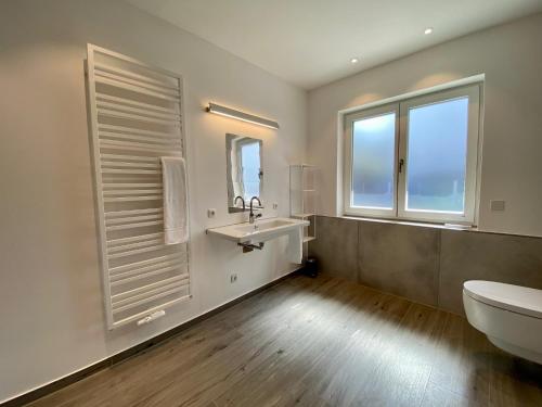 a bathroom with a sink and a toilet and a window at "Mittendrin" in Garmisch in Garmisch-Partenkirchen