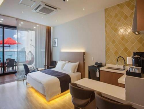 a hotel room with a bed and a kitchen at Demare Pension in Yeosu