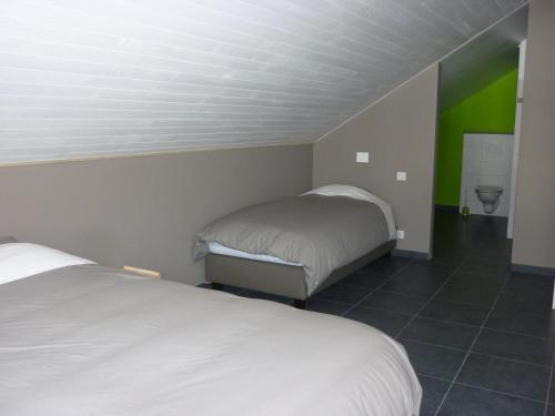 a bedroom with two beds and a green wall at Les midis au vert - Les Loges - 11 personnes in Stavelot