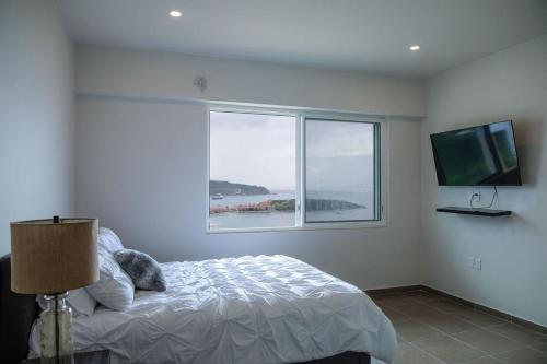 Habitación blanca con cama y ventana en Picturesque 1 bedroom apartment, en Koolbaai