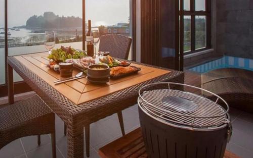 a table with a plate of food and glasses of wine at Demare Pension in Yeosu