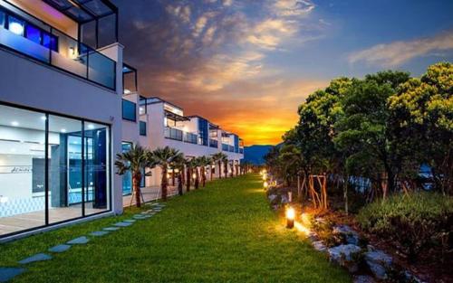 a lawn with lights in front of a building at Demare Pension in Yeosu