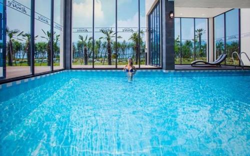 a woman in a swimming pool in a building at Demare Pension in Yeosu