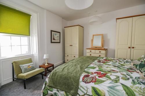 - une chambre avec un lit, une chaise et un miroir dans l'établissement 3 Clarks Terrace, à Maryport