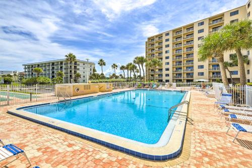 a large swimming pool with chairs and a building at Cape Canaveral Condo with On-Site Beach Access! in Cape Canaveral