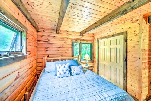 ein Schlafzimmer mit einem Bett in einer Holzhütte in der Unterkunft Log Cabin 9 Mi to Plattekill and Belleayre Mtn in Denver