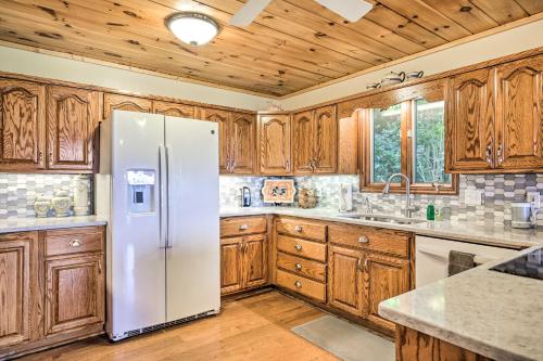 a kitchen with a refrigerator and wooden cabinets at Hiawassee Home with Fire Pit and Furnished Deck! in Hiawassee