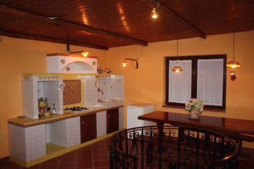 a kitchen with a table and a stove top oven at Villa Delle Camelie in Gragnano