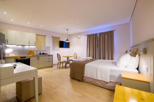 a hotel room with a bed and a kitchen at Kannas Luxury Suites Mani in Stoupa