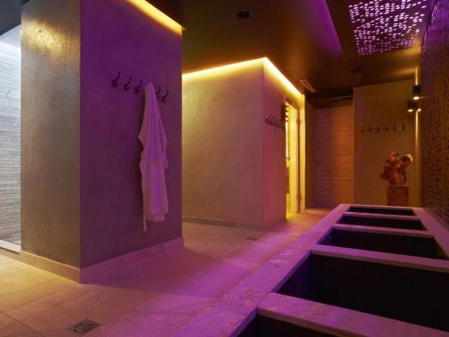 ein Badezimmer mit violetter Beleuchtung und einer Badewanne in der Unterkunft GRÜNER Alpengasthof inkl Summercard in Sölden