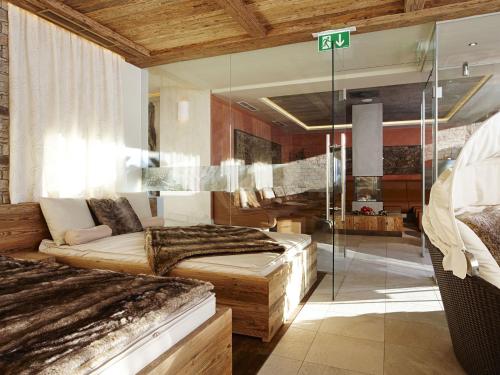 a bedroom with two beds and a glass wall at GRÜNER Alpengasthof inkl Summercard in Sölden
