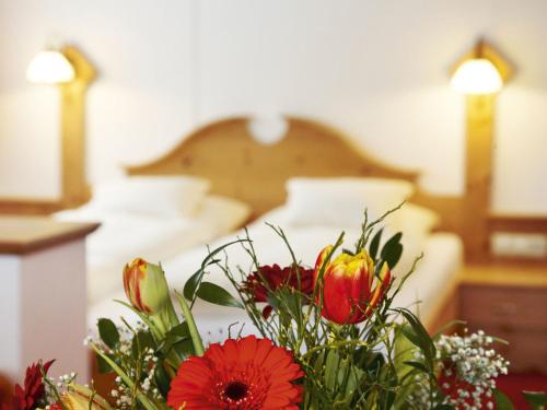 a bouquet of flowers in front of a bed at Alpengasthof Grüner in Sölden