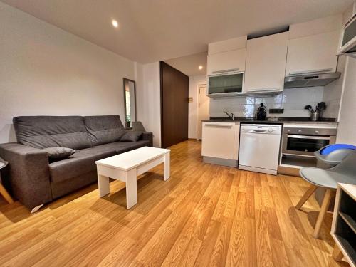 a living room with a couch and a kitchen at Avet A 2.2 Hasta 4 personas. in El Tarter