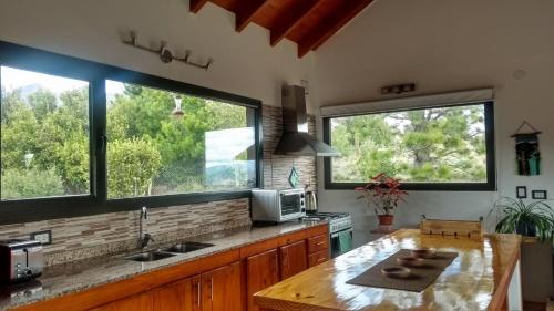 a kitchen with two large windows and a counter top at La Casa del Viento in San Martín de los Andes