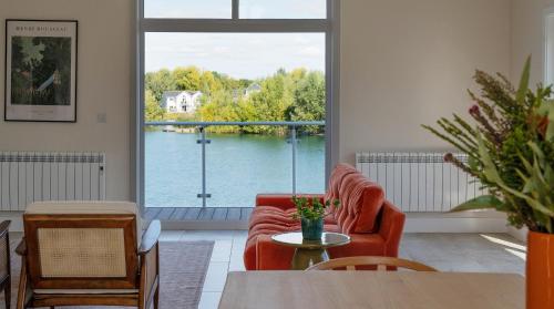 a living room with a view of the water at Gorgeous 4 bedroom Cotswolds home with lake view in South Cerney