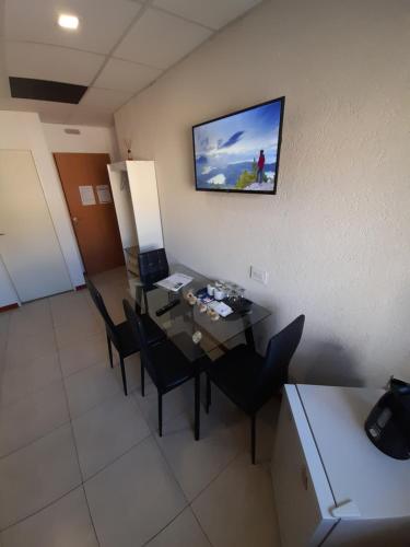 a room with a table with chairs and a television on the wall at Suite in Tres Arroyos