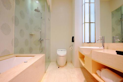 a bathroom with a tub and a toilet and a sink at City Suites - Taipei Nandong in Taipei
