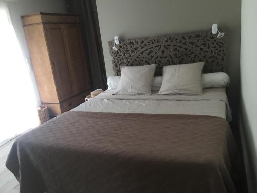 - une chambre avec un grand lit et une tête de lit en bois dans l'établissement Chambre d hôtes Cabries Calas 5 min gare TGV Aix, à Cabriès