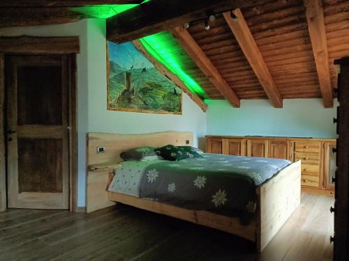 a bedroom with a wooden bed with green lights at Le temps Retrouvé - casa tipica con giardino in Villeneuve