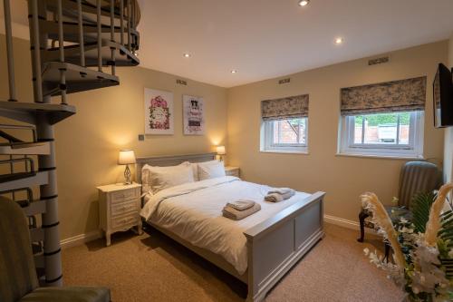 a bedroom with a bed and two windows at Stylish Central 2 Bedroom Apartment in Hereford