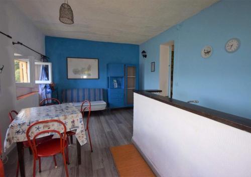 een kamer met een tafel en stoelen en een blauwe muur bij Cotetonda - Appartamento Ilvia in Marciana Marina