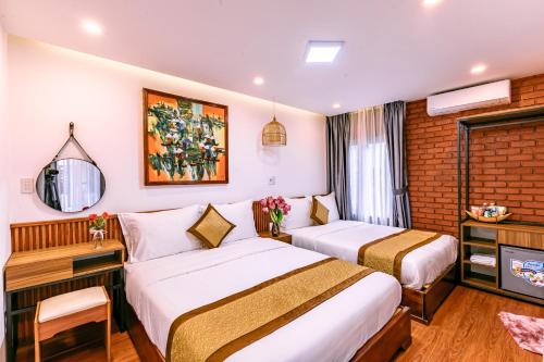 a hotel room with two beds and a television at Nana Homestay & Villa in Hue