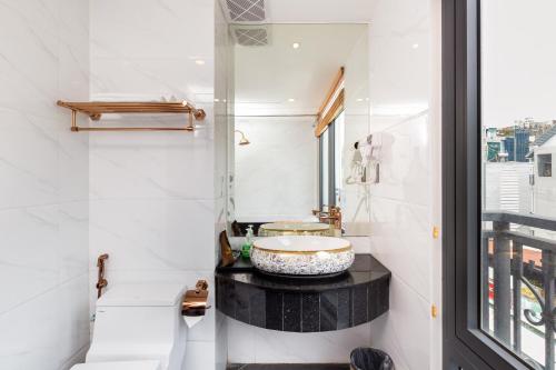 a bathroom with a sink and a window at Silk Hong Ha airport hotel in Ho Chi Minh City