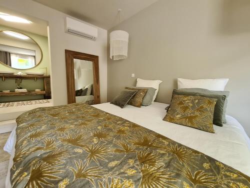 a bedroom with two beds and a mirror at La Maison de Lyna - Suites de charme intra-muros avec parking & autonomie in Aigues-Mortes