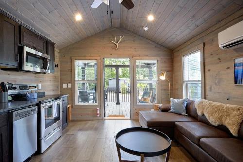 a kitchen and living room with a couch and a table at Asheville River Cabins in Arden