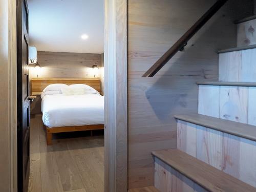 a bedroom with a white bed and a staircase at Asheville River Cabins in Arden