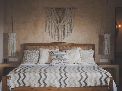 a bed with black and white sheets and pillows at Vaayu Kula mandrem in Mandrem