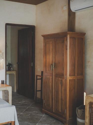 a room with a wooden cabinet next to a door at Vaayu Kula mandrem in Mandrem