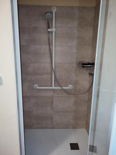 a shower with a hose in a bathroom at chambre d'hôtes chez DENFLO in Sevremont