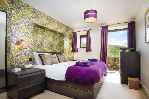 a bedroom with a bed with a purple blanket at Coomb View at Sandbeds in Kendal