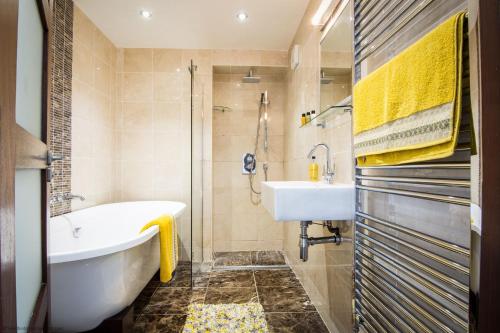 ein Badezimmer mit einer Badewanne und einem Waschbecken in der Unterkunft Coomb View at Sandbeds in Kendal