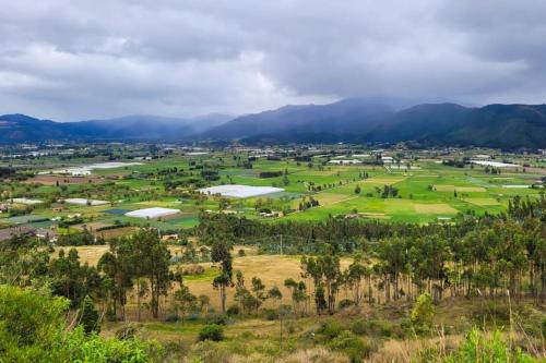 an aerial view of a farm with mountains in the background at Casa de ensueño Alto Turmequé a 5 min de Tibasosa in Tibasosa