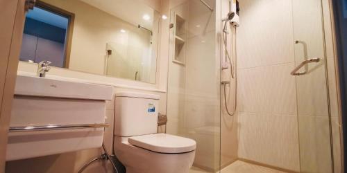 een witte badkamer met een toilet en een douche bij Asok - Din Daeng Apartment in Bangkok