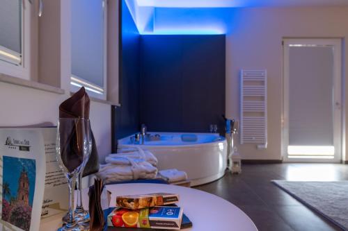 a bathroom with a tub and a table in a room at Hotel Torre Del Sud in Modica