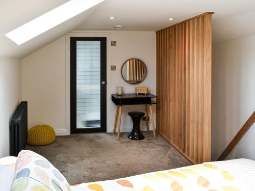een slaapkamer met een bureau, een bed en een tafel bij Dove Cottage in Knaresborough