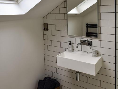 een badkamer met een witte wastafel en een spiegel bij Dove Cottage in Knaresborough