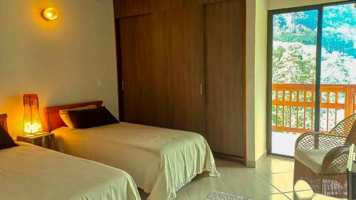 a hotel room with two beds and a balcony at La Casa Amarilla in Jardin