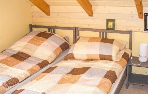 2 camas en una habitación con paredes de madera en Awesome Home In Dywity With House Sea View, en Dywity