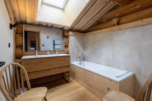 a bathroom with a tub and a sink and a mirror at Chalet L'Axurit - Familial Jacuzzi Sauna in La Cabanasse
