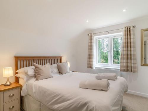 a bedroom with a white bed with two towels on it at Canal View House - Uk39363 in Swafield