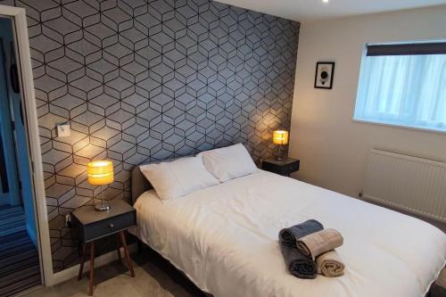 Comfortable 1 Bed flat with Air Con في بورِهاموود: غرفة نوم بسرير ومصباحين ونافذة