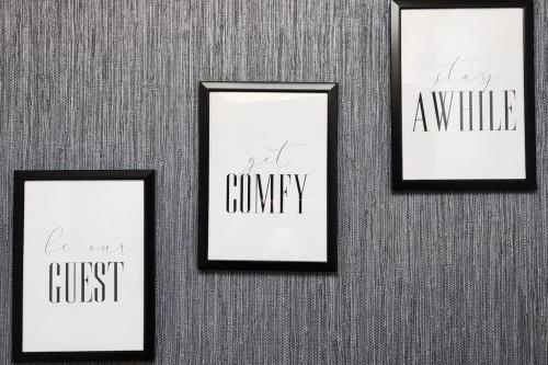 three frames with writing on them on a wall at Comfortable 1 Bed flat with Air Con in Borehamwood