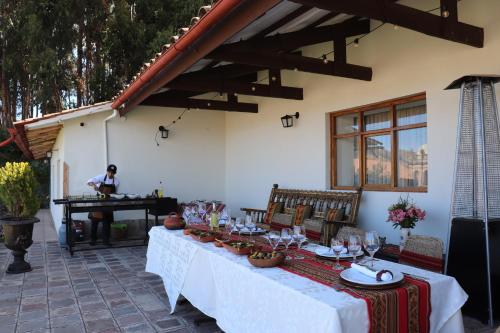 a table with white table cloths and a person on a piano at Palacio Manco Capac by Ananay Hotels in Cusco